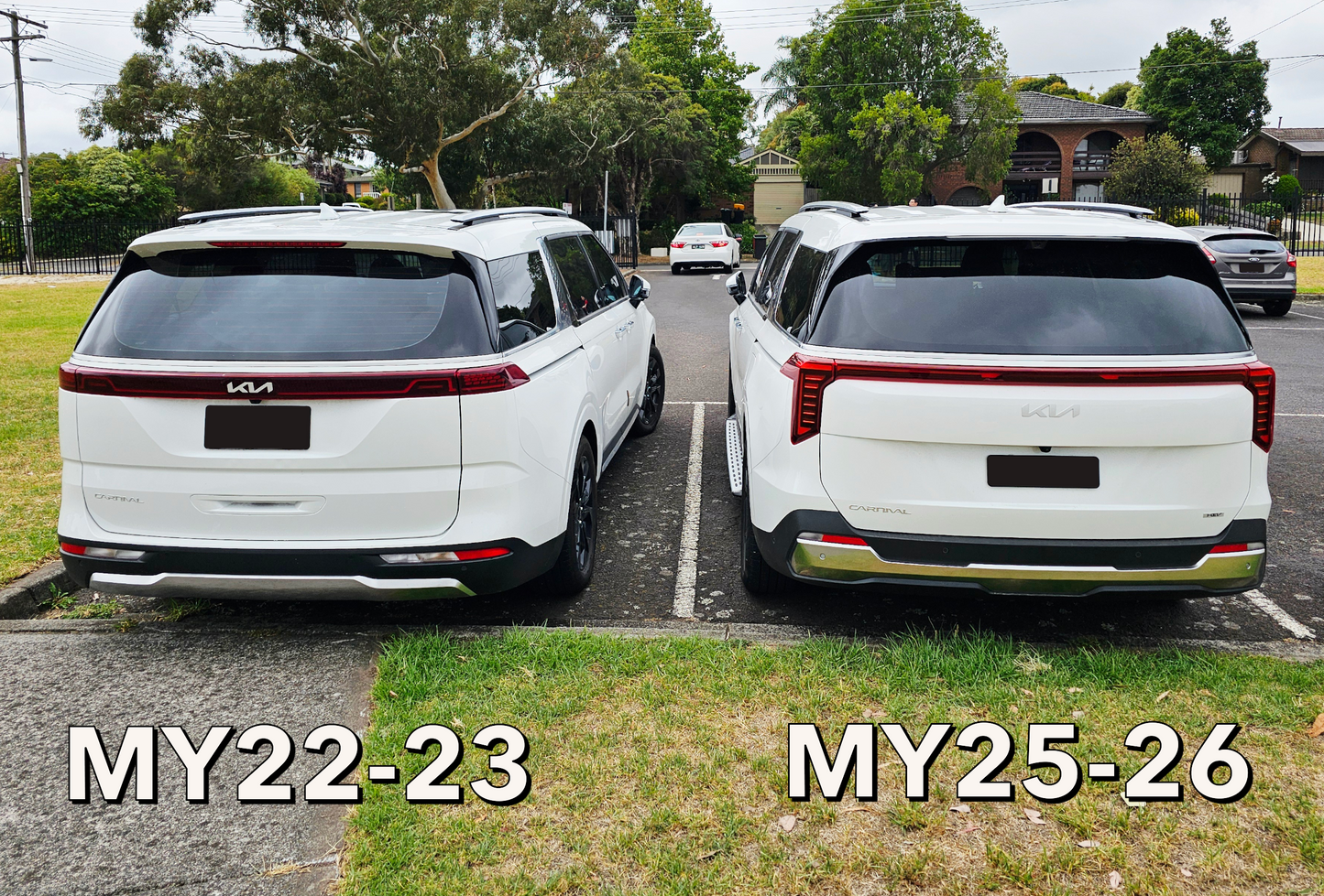 Two white Kia vehicles, one labeled MY22-23 and the other labeled MY25-26, parked side by side on a grassy area.