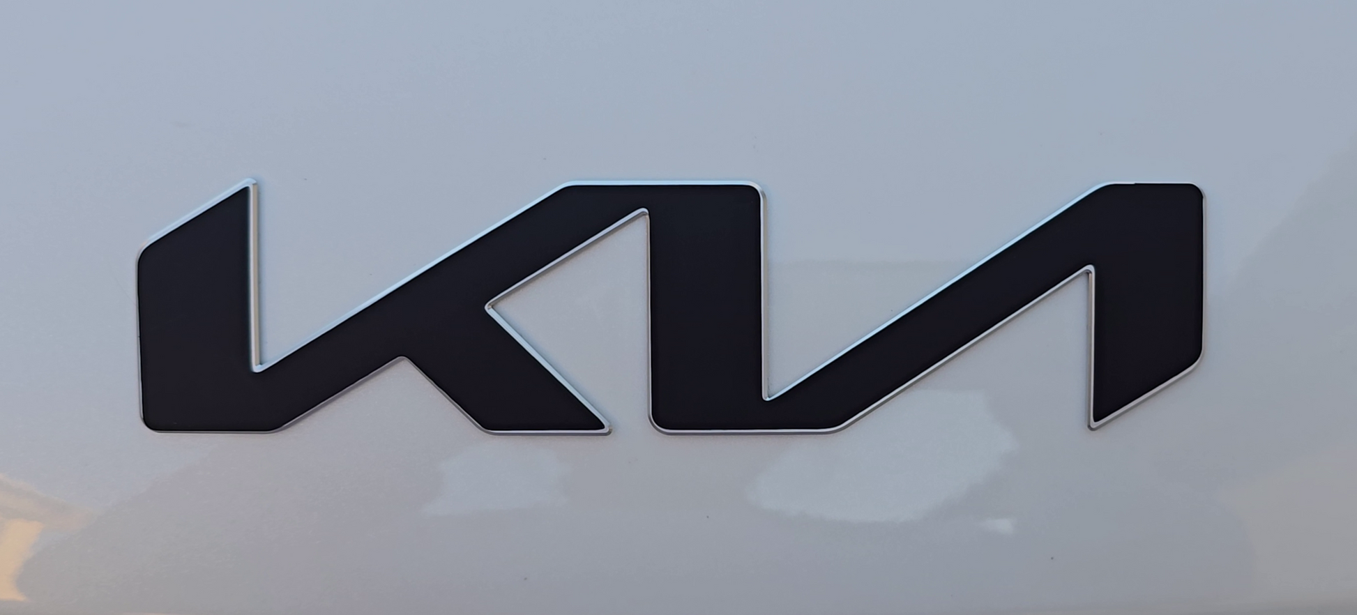 Matte Black Kia emblem overlay on a white background